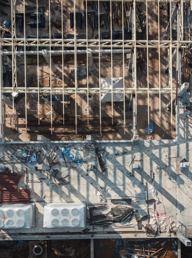 Aerial View Construction Site. Workers Fixing Grid Foundation Bars. Progress and Activity on the Rooftop.